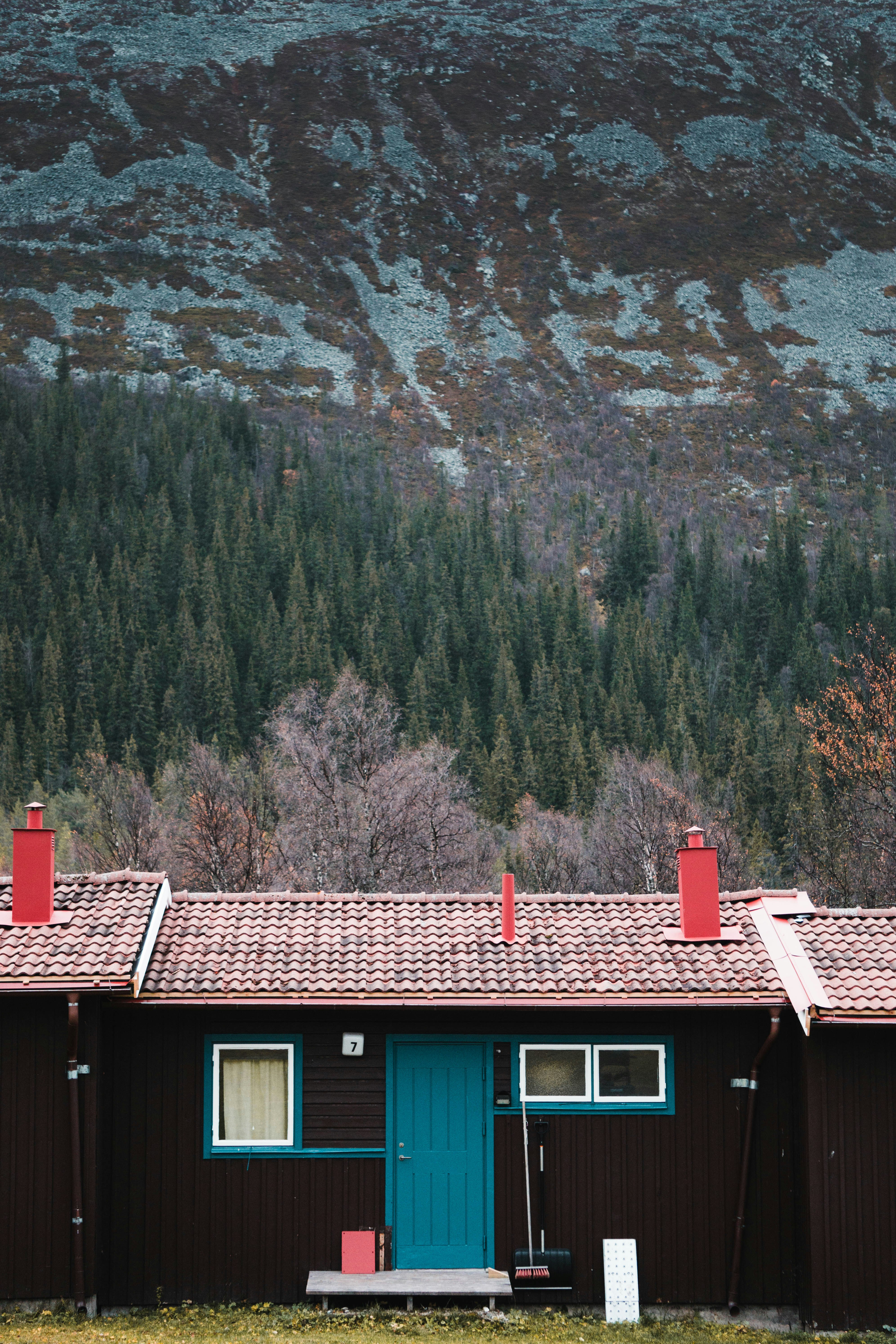 brown wooden house near rocky mountain